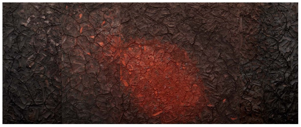 A textured dark surface with a prominent red circular area, resembling cracked earth or lava.
